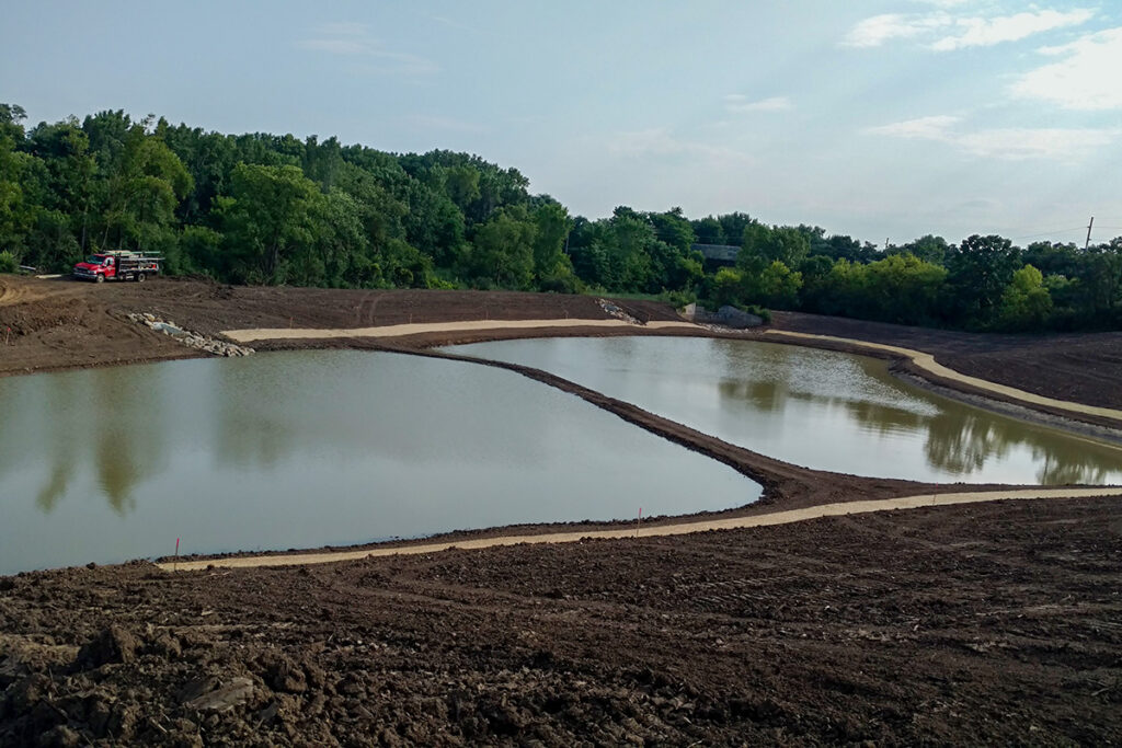 Constructed stormwater pond with shaped embankments and surrounding earthwork