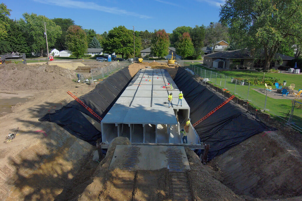 Aerial view of large concrete box culvert installation in a residential construction site